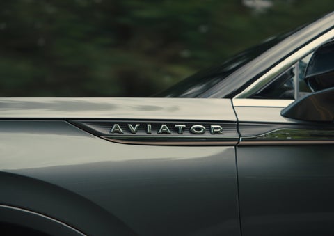 The driver’s side door and fender badging of a gray 2027 Lincoln Aviator® SUV are showcased. | Randy Marion Lincoln in Statesville NC