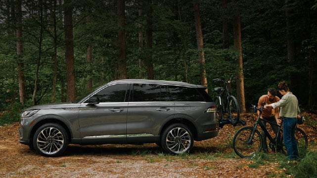 A father and son load e-bikes on a bike rack attached to a 2027 Lincoln Aviator® SUV. | Randy Marion Lincoln in Statesville NC