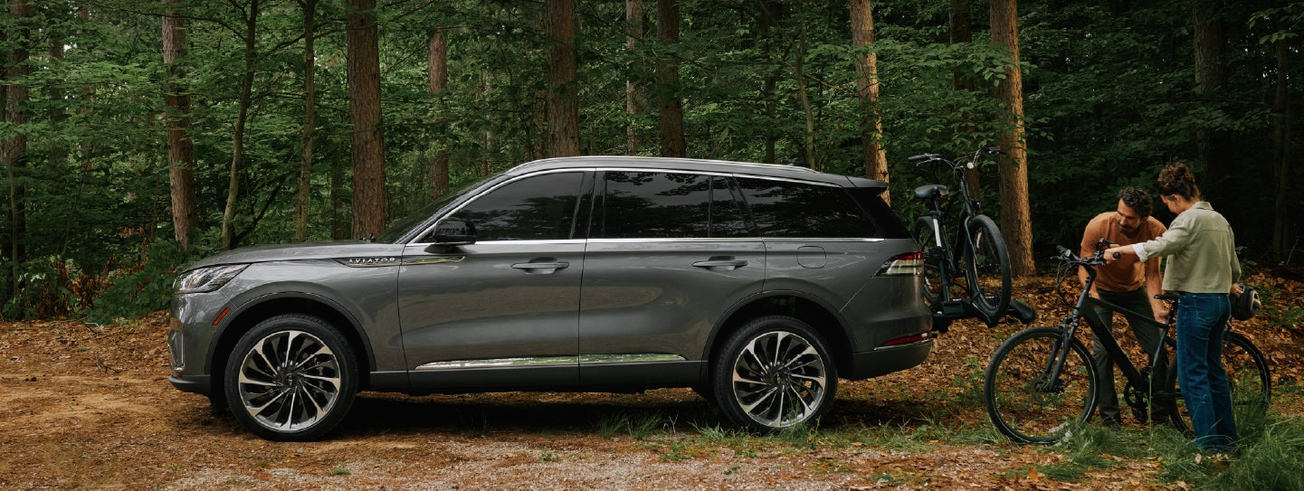 A father and son load e-bikes on a bike rack attached to a 2027 Lincoln Aviator® SUV. | Randy Marion Lincoln in Statesville NC
